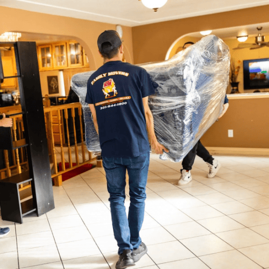movers lifting wrapped couch.